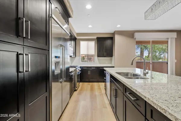 a kitchen with stainless steel appliances granite countertop a sink and a refrigerator