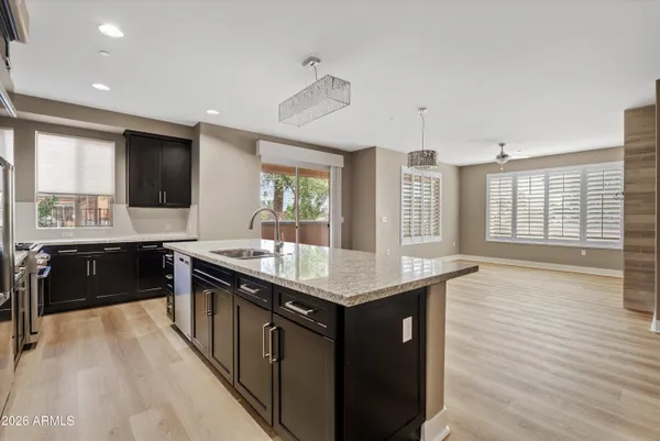 a kitchen with stainless steel appliances granite countertop a sink stove and wooden floor