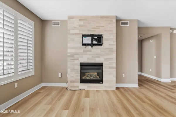 a view of an empty room with a fireplace and a window