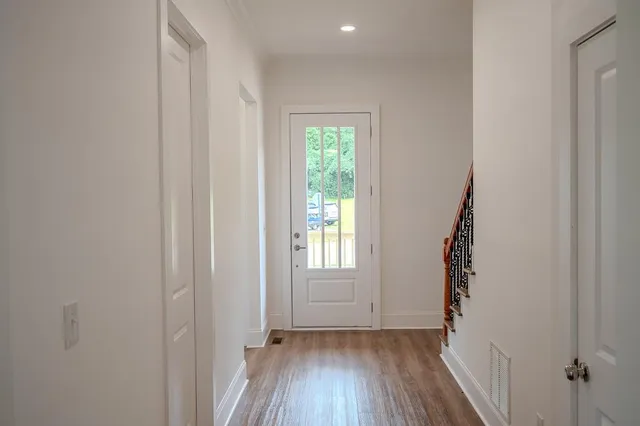 a view of hallway with window and wooden floor
