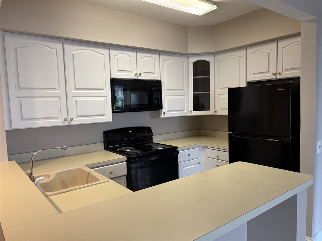 34 Sumner Avenue, Unit 411 Springfield, MA 01108 - Photo 3 of 8 a kitchen with a refrigerator stove and microwave