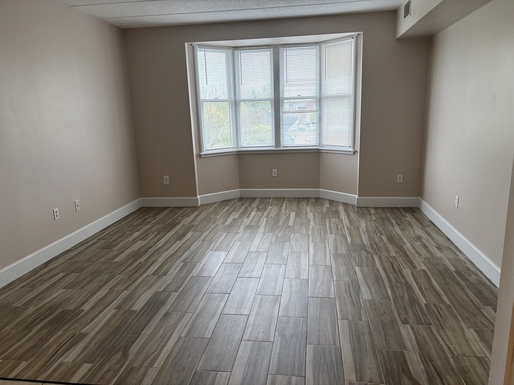 34 Sumner Avenue, Unit 411 Springfield, MA 01108 - Photo 4 of 8 wooden floor in an empty room with a window