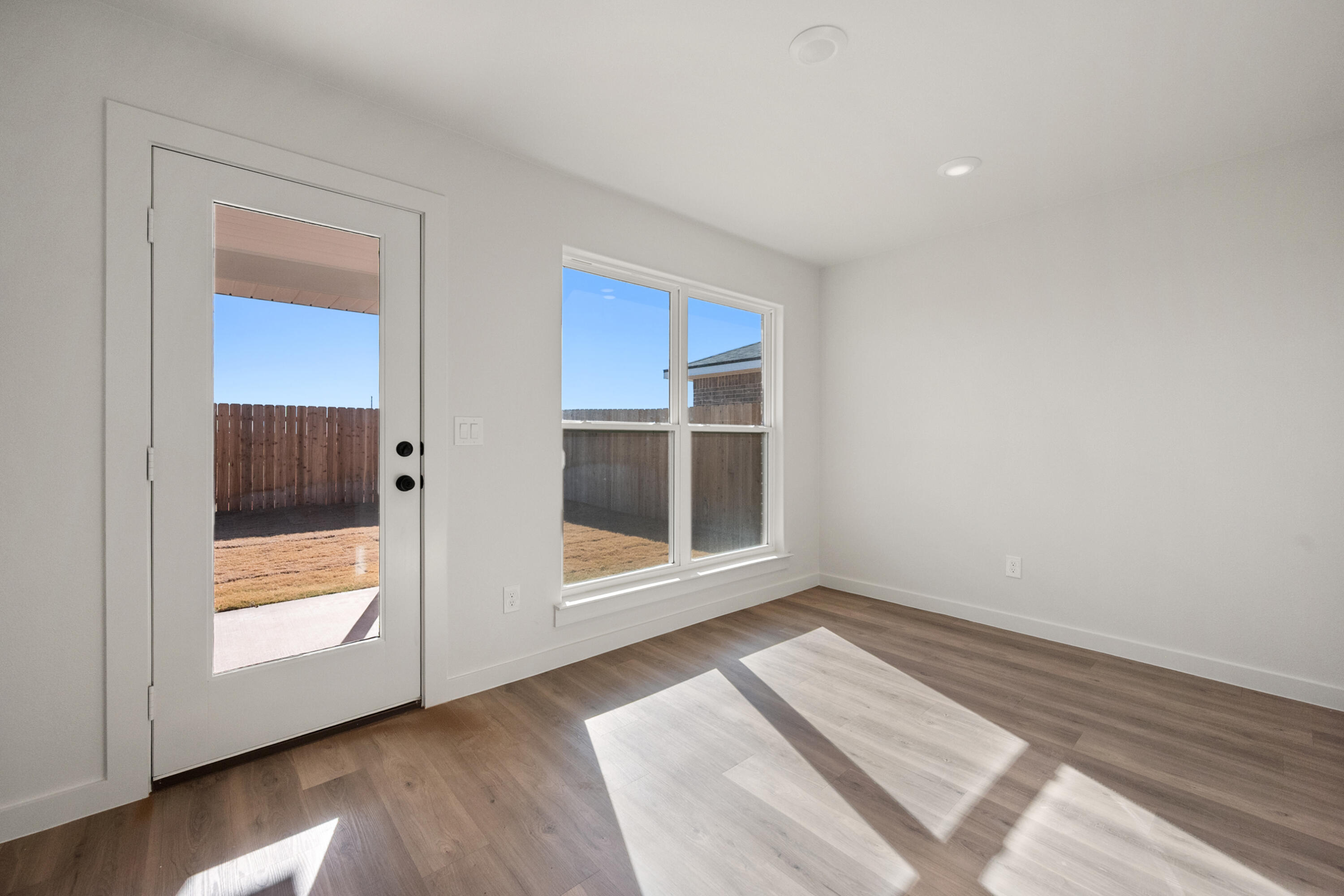 8305 24th Street Lubbock, TX 79407 - Photo 15 of 25 a view of an empty room with wooden floor and a window
