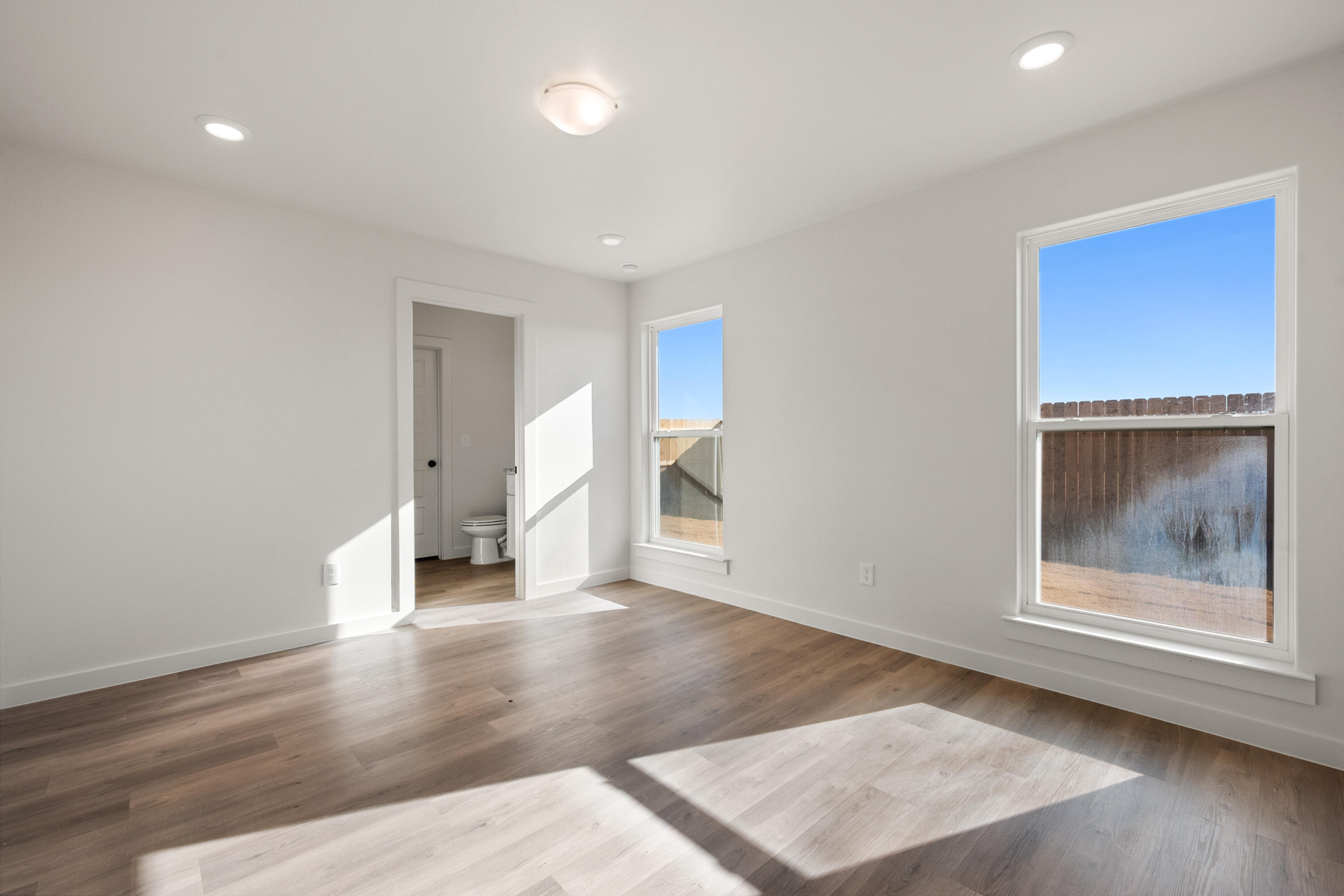 8305 24th Street Lubbock, TX 79407 - Photo 16 of 25 a view of an empty room with wooden floor and a window
