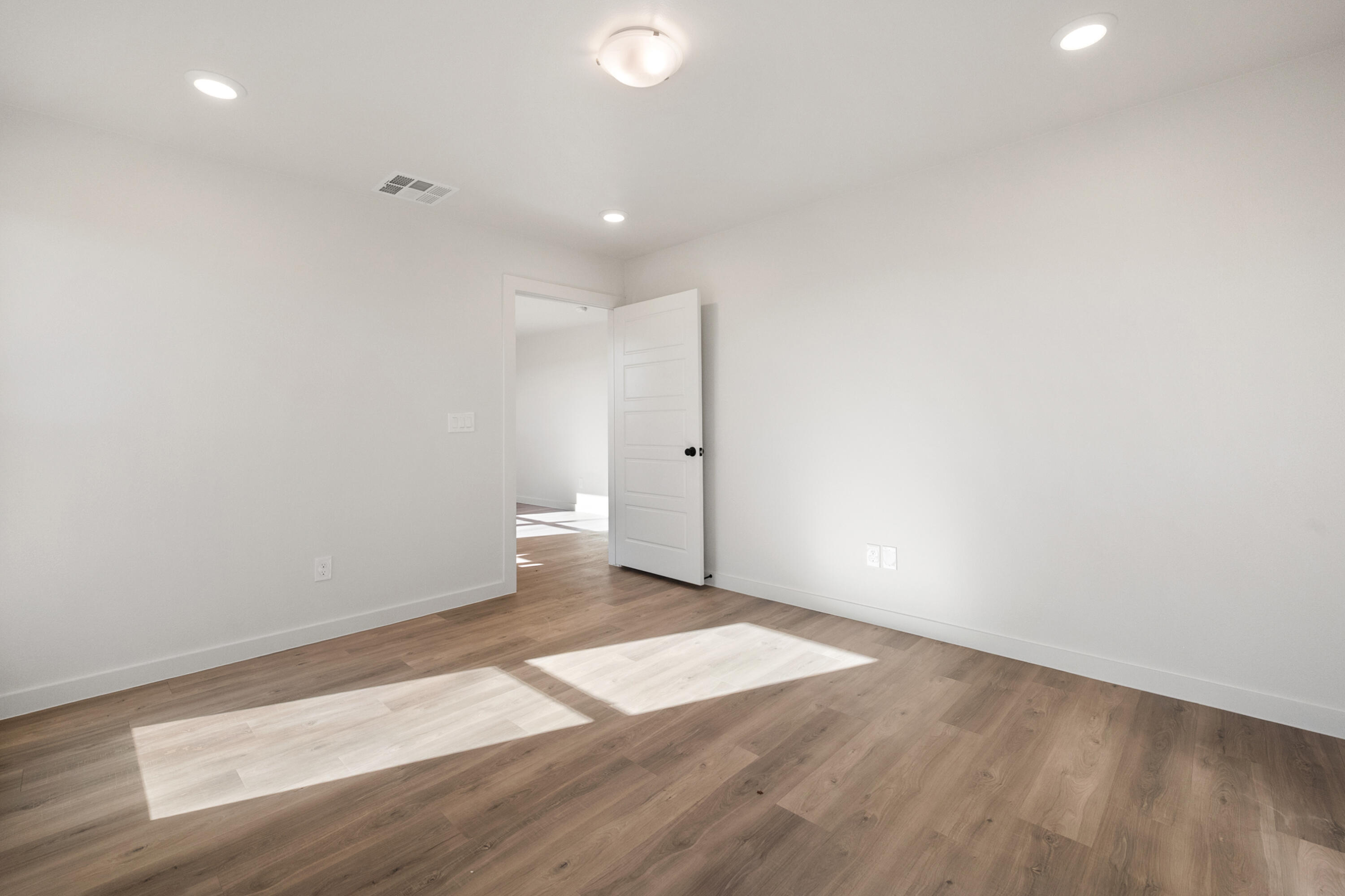 8305 24th Street Lubbock, TX 79407 - Photo 17 of 25 an empty room with wooden floor and white walls