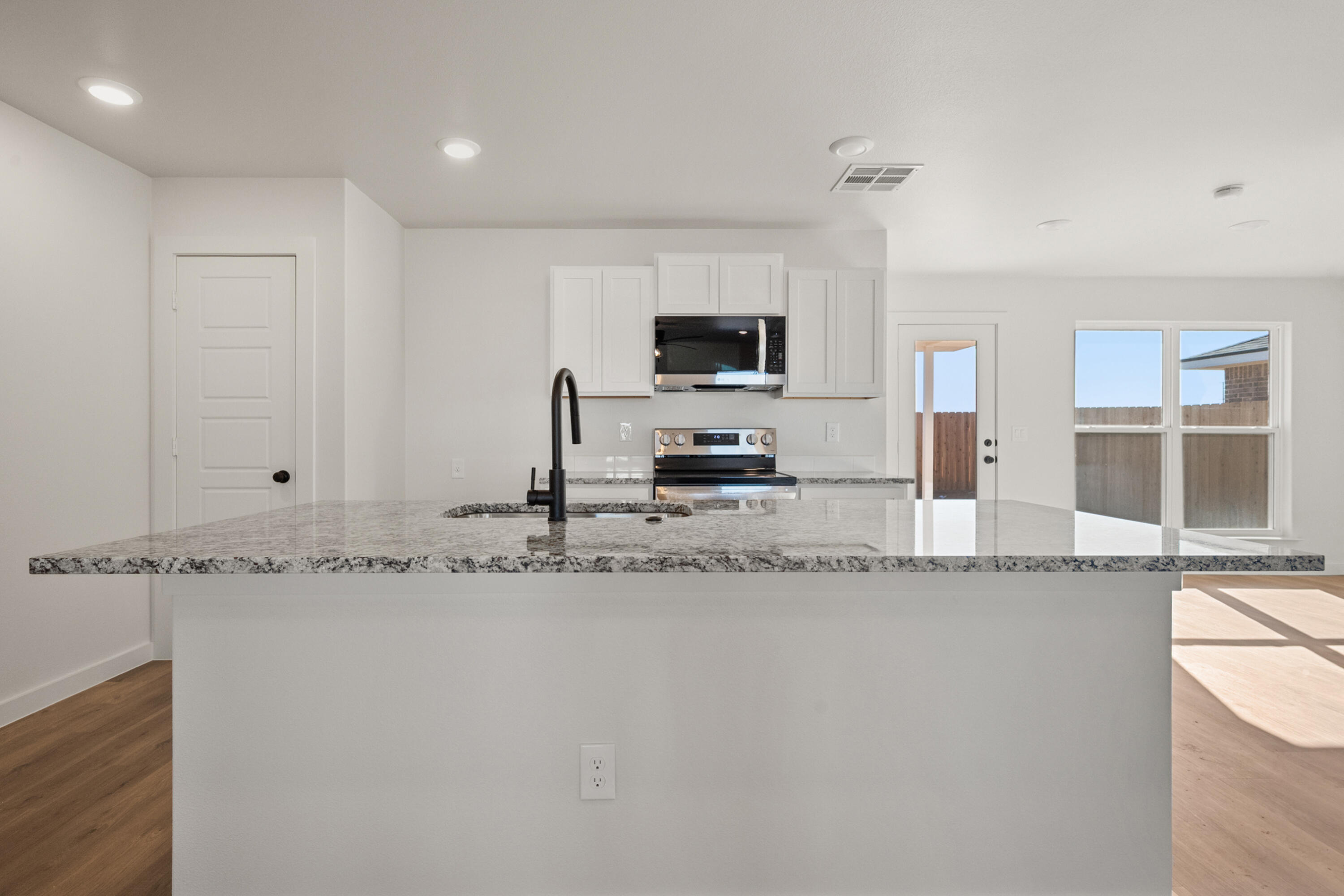 8305 24th Street Lubbock, TX 79407 - Photo 9 of 25 a kitchen with stainless steel appliances granite countertop a sink a stove and a granite counter top