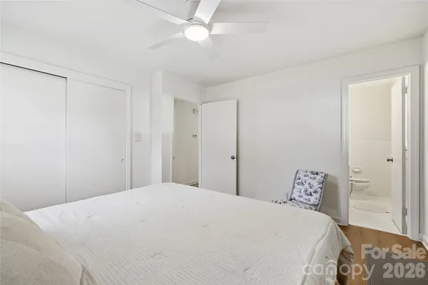 a bedroom with a large bed and a chandelier fan