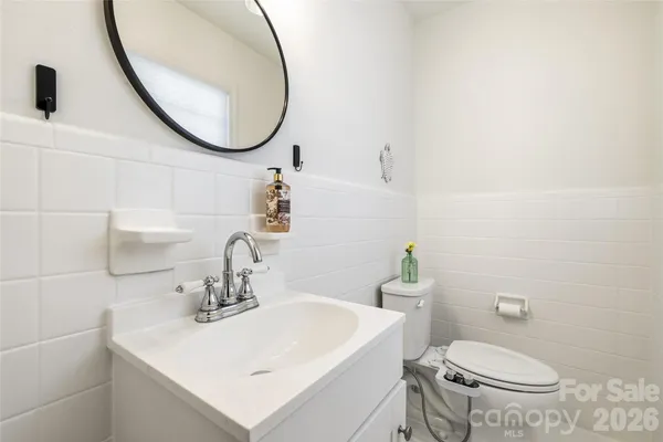 a bathroom with a sink a toilet and a mirror