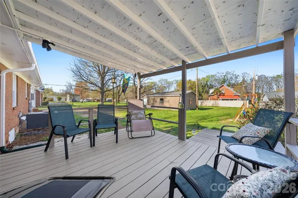 a view of a patio with lawn chairs floor to ceiling window with wooden floor