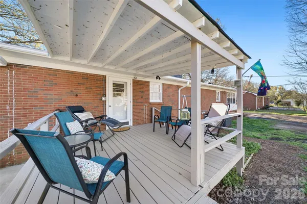 a view of a patio with table and chairs with wooden floor and fence