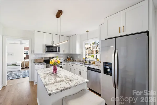 a kitchen with white cabinets and stainless steel appliances