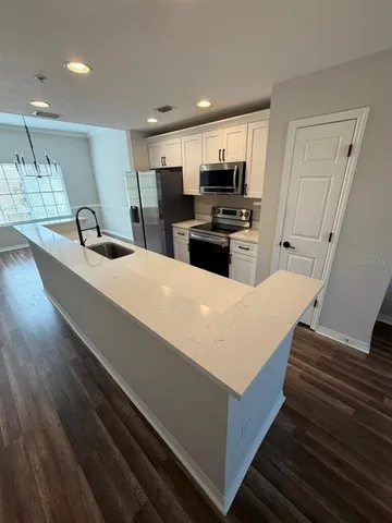 a large kitchen with kitchen island a sink stainless steel appliances and cabinets