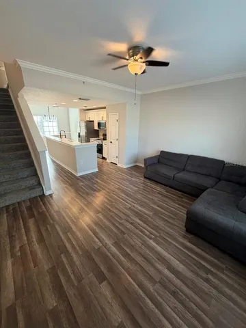 a living room with furniture and a wooden floor