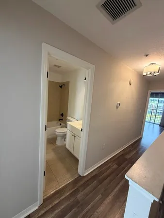 a view of a hallway and a livingroom with furniture
