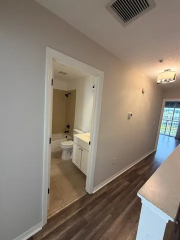 a view of a hallway and a livingroom with furniture