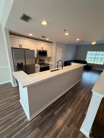 a kitchen with stainless steel appliances a refrigerator sink and microwave