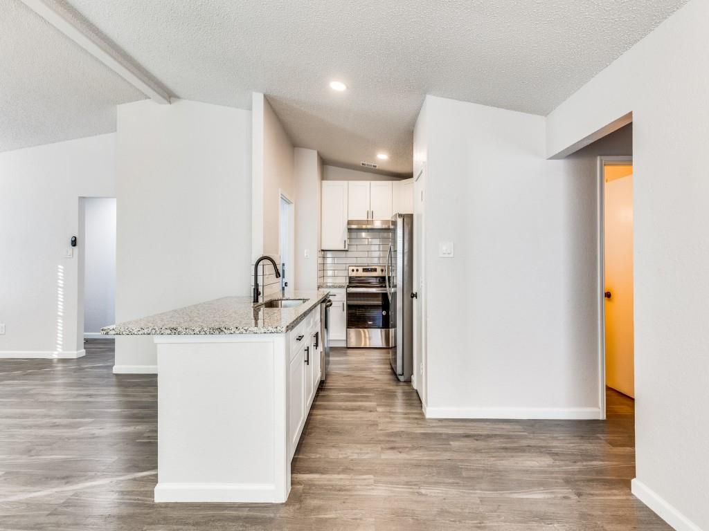 7457 Tiffany Meadows Lane Fort Worth, TX 76140 - Photo 12 of 18 a kitchen with stainless steel appliances granite countertop a sink stove and refrigerator