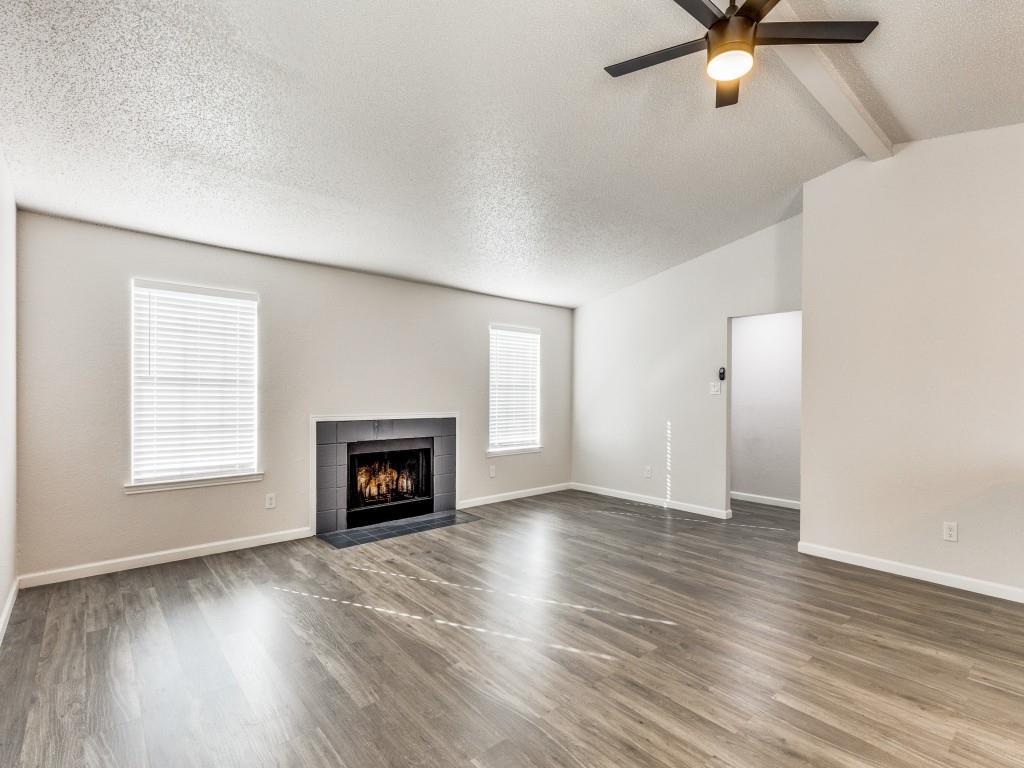 7457 Tiffany Meadows Lane Fort Worth, TX 76140 - Photo 5 of 18 an empty room with windows fireplace and wooden floor