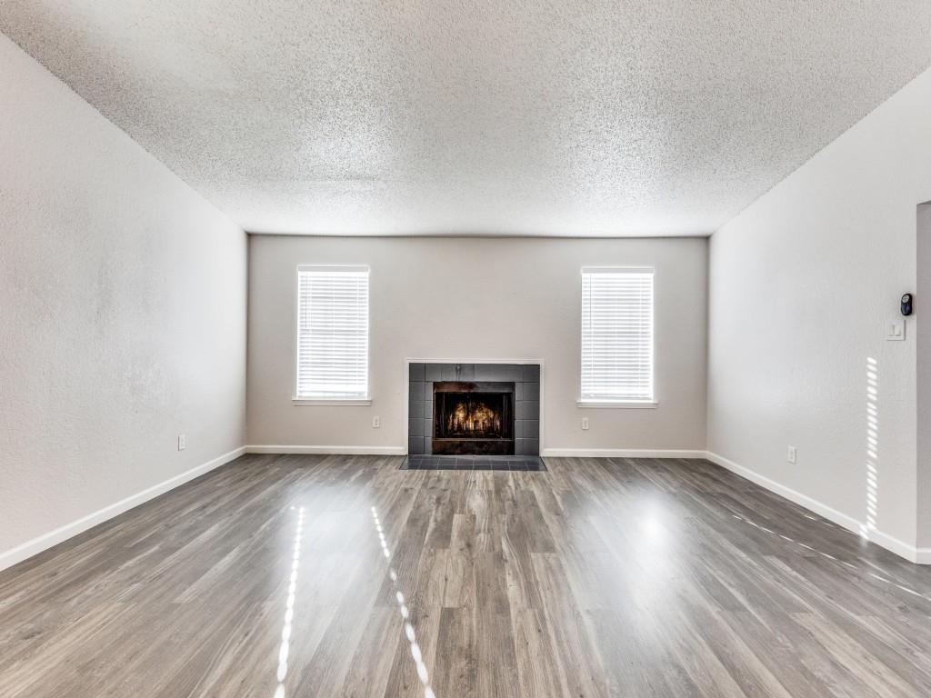 7457 Tiffany Meadows Lane Fort Worth, TX 76140 - Photo 6 of 18 an empty room with wooden floor fireplace and windows