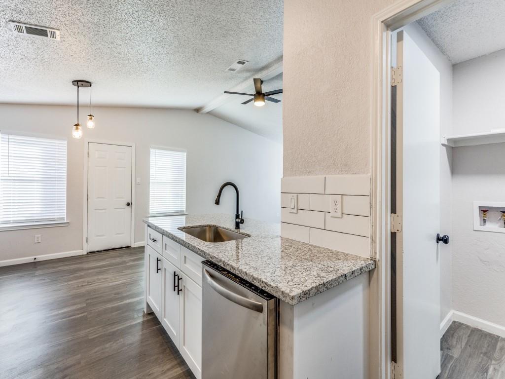 7457 Tiffany Meadows Lane Fort Worth, TX 76140 - Photo 9 of 18 an open kitchen with granite countertop a sink and white cabinets