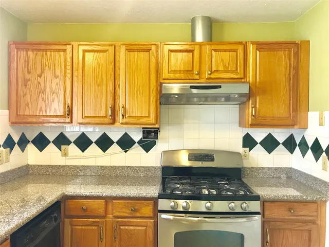 a kitchen with granite countertop a sink and a stove