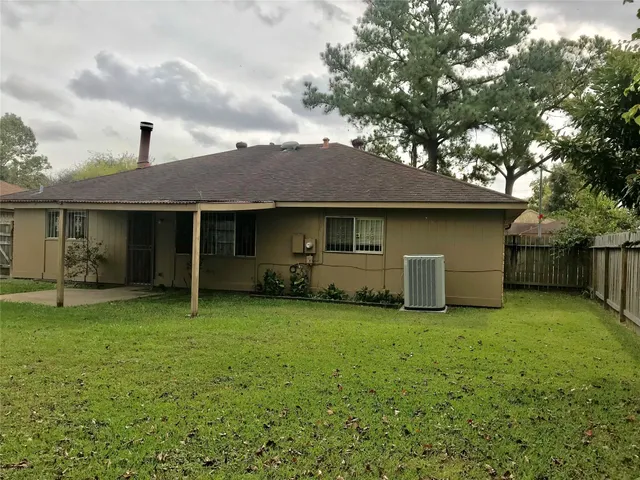a view of a house with a yard and large tree