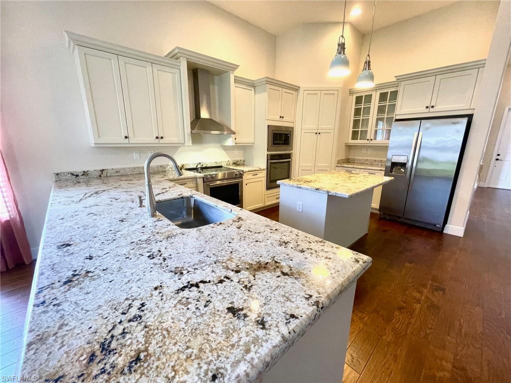 5375 Ferrari Avenue Ave Maria, FL 34142 - Photo 12 of 45 a kitchen with stainless steel appliances kitchen island granite countertop a sink stove and refrigerator