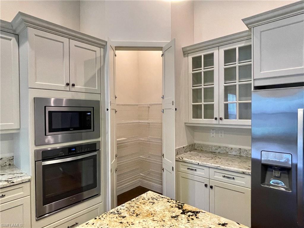 5375 Ferrari Avenue Ave Maria, FL 34142 - Photo 13 of 45 a kitchen with granite countertop a stove oven and cabinets