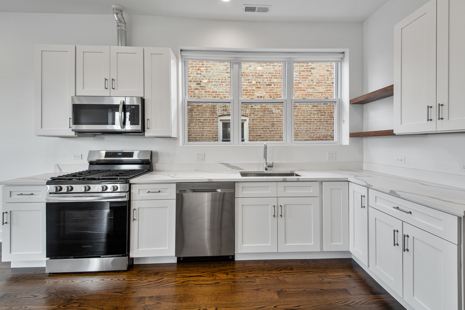2316 West Augusta Boulevard, Unit 2R Chicago, IL 60622 - Photo 2 of 5 a kitchen with stainless steel appliances granite countertop a stove a sink and a microwave