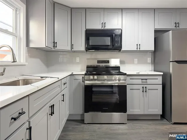 a kitchen with stainless steel appliances granite countertop a stove a microwave and a refrigerator