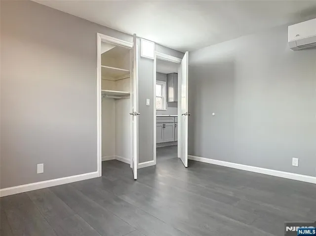 an empty room with wooden floor & closet and windows