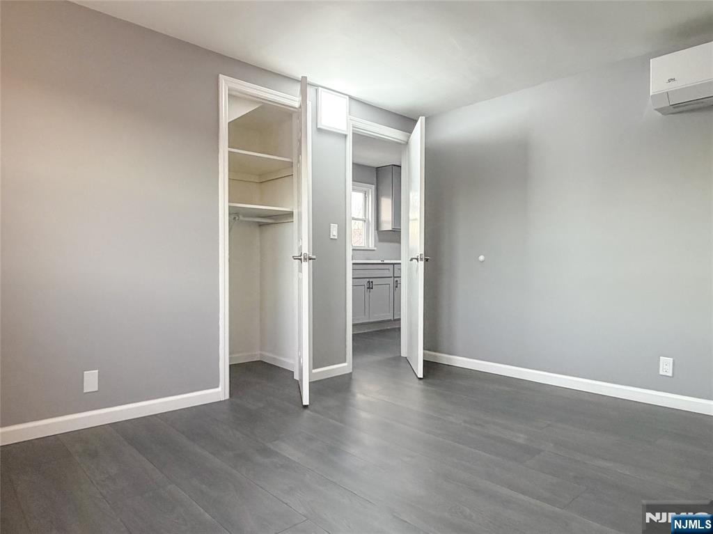 90 East 9th Street, Unit 2 Clifton, NJ 07011 - Photo 13 of 14 an empty room with wooden floor & closet and windows