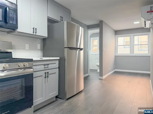 a kitchen with stainless steel appliances granite countertop a refrigerator sink and wooden floor