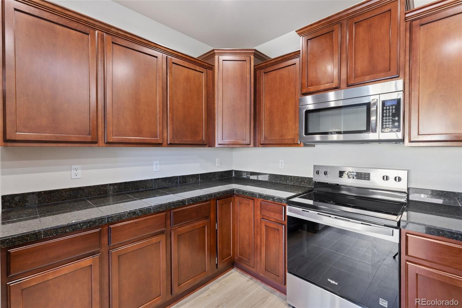 5645 Saint Patrick View Colorado Springs, CO 80923 - Photo 21 of 33 a kitchen with granite countertop a sink and cabinets