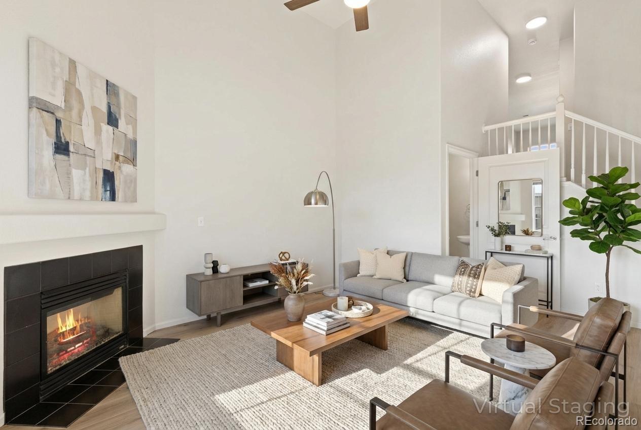 5645 Saint Patrick View Colorado Springs, CO 80923 - Photo 10 of 33 a living room with furniture a fireplace and a potted plant