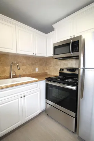 a kitchen with stainless steel appliances white cabinets and a sink