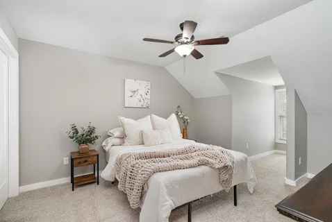 a bedroom with a bed chandelier and a window