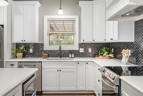 a kitchen with white cabinets and white appliances