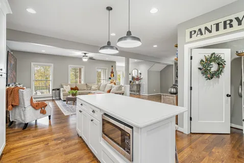 a large kitchen with kitchen island a island a stove a sink a refrigerator and a dining table view