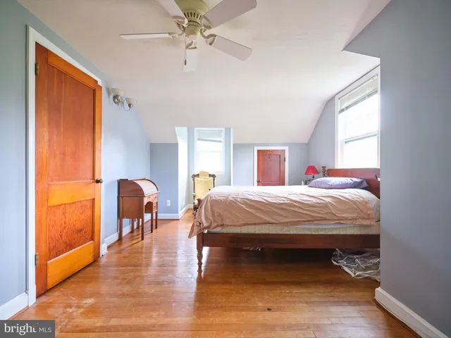 a bed sitting in a spacious bedroom next to a window