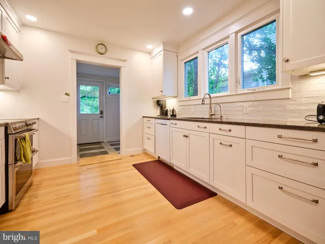 a large kitchen with stainless steel appliances granite countertop a sink and cabinets