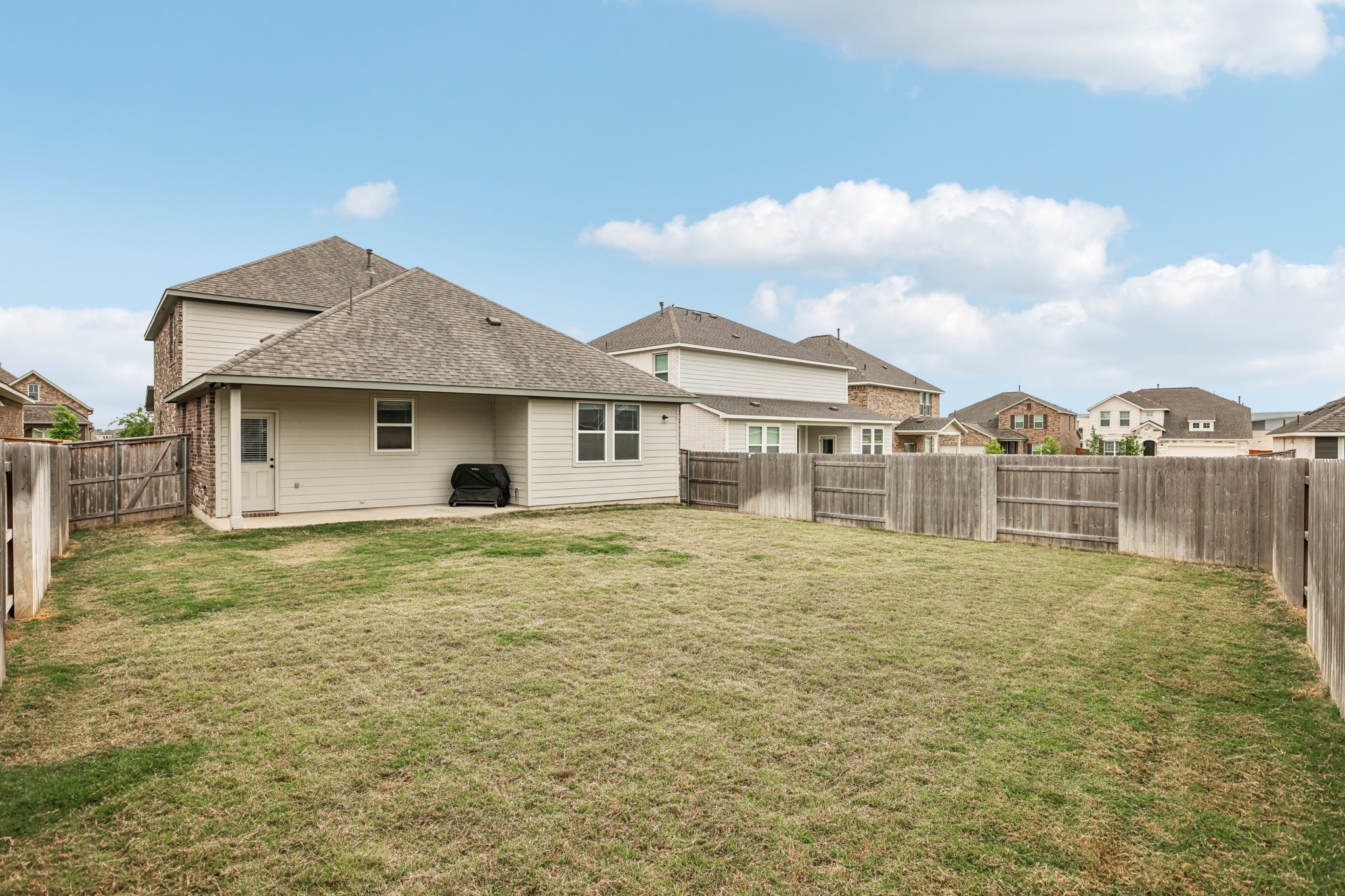 204 Swinging H Lane Georgetown, TX 78633 - Photo 32 of 39 The property features an extensive backyard with a lawn and wooden privacy fencing