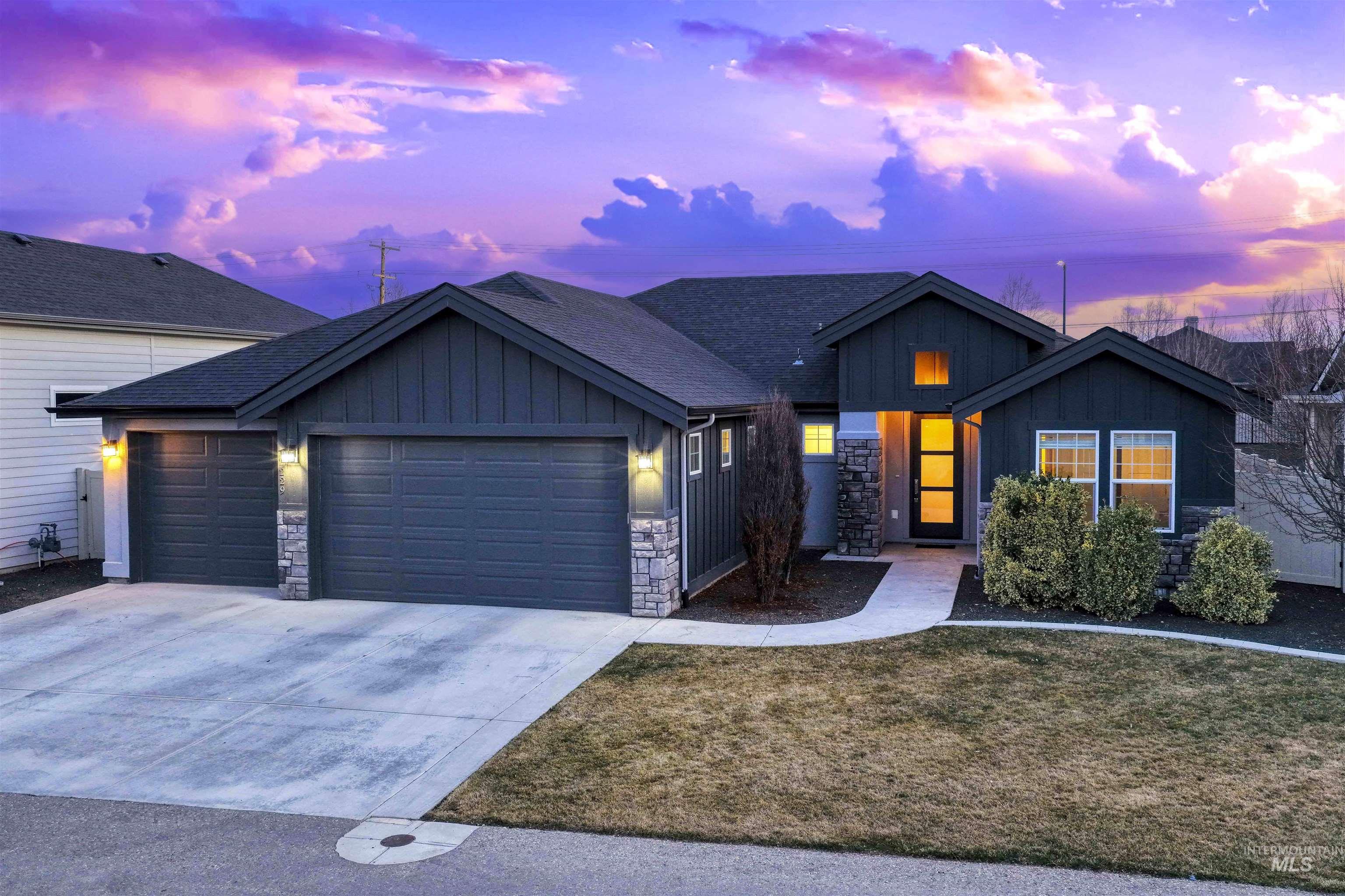 2229 East Grayson Street Meridian, ID 83642 - Photo 2 of 40 View of front of home featuring board and batten siding, stone siding, a garage, concrete driveway, and a front lawn