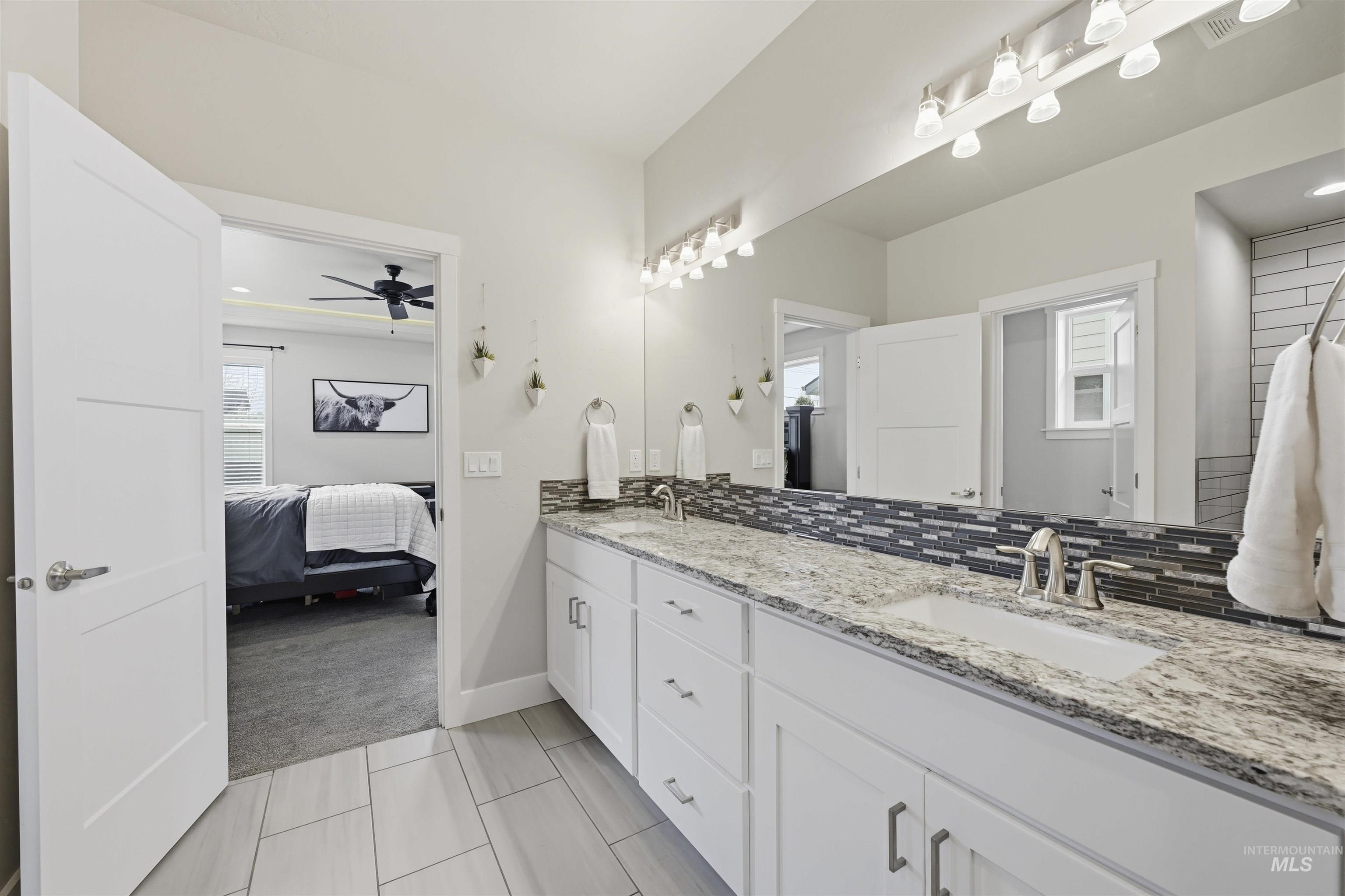 2229 East Grayson Street Meridian, ID 83642 - Photo 25 of 40 Ensuite bathroom with double vanity, decorative backsplash, light carpet, and a ceiling fan