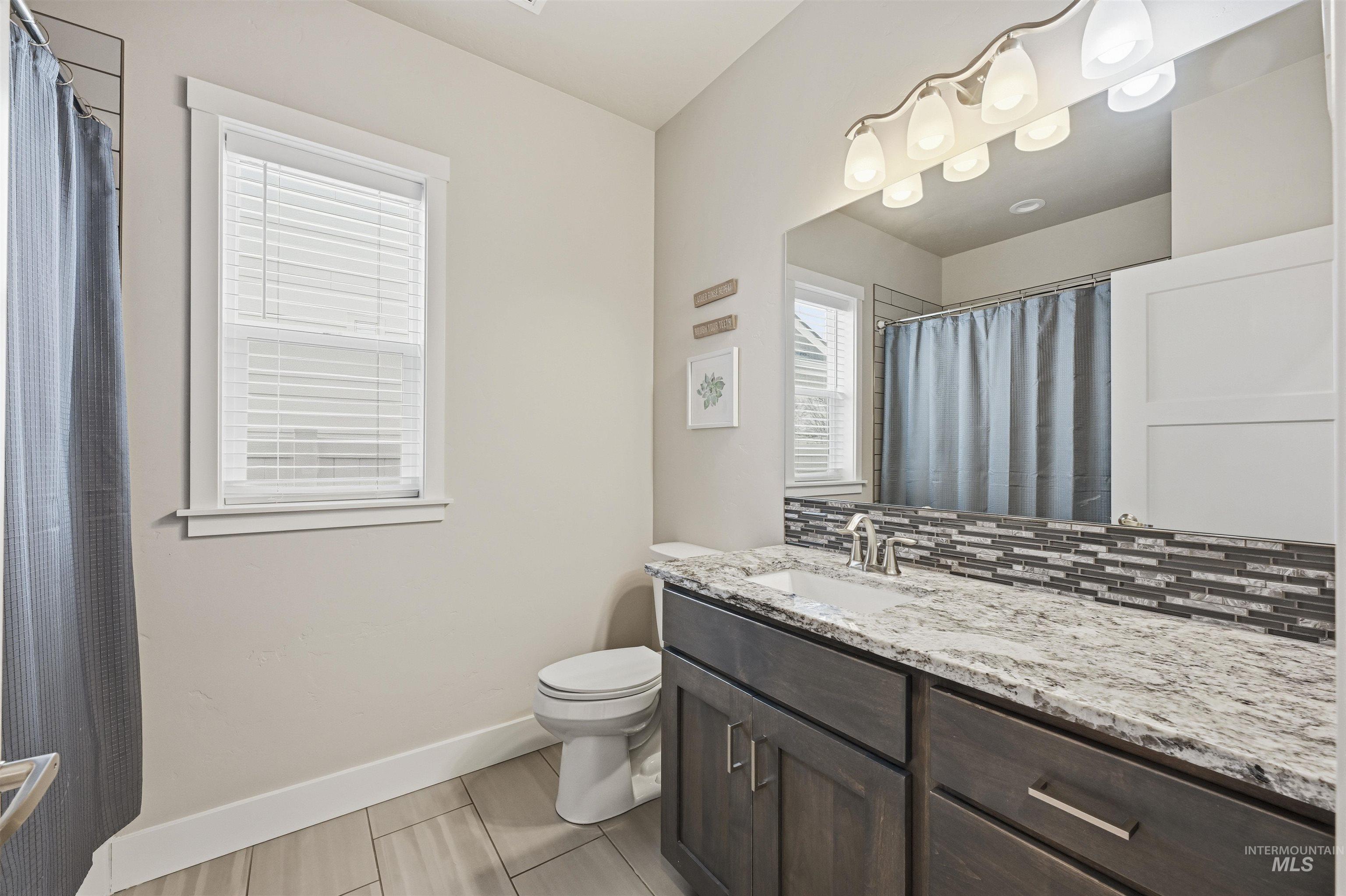 2229 East Grayson Street Meridian, ID 83642 - Photo 29 of 40 Full bath featuring vanity, a shower with shower curtain, and tasteful backsplash