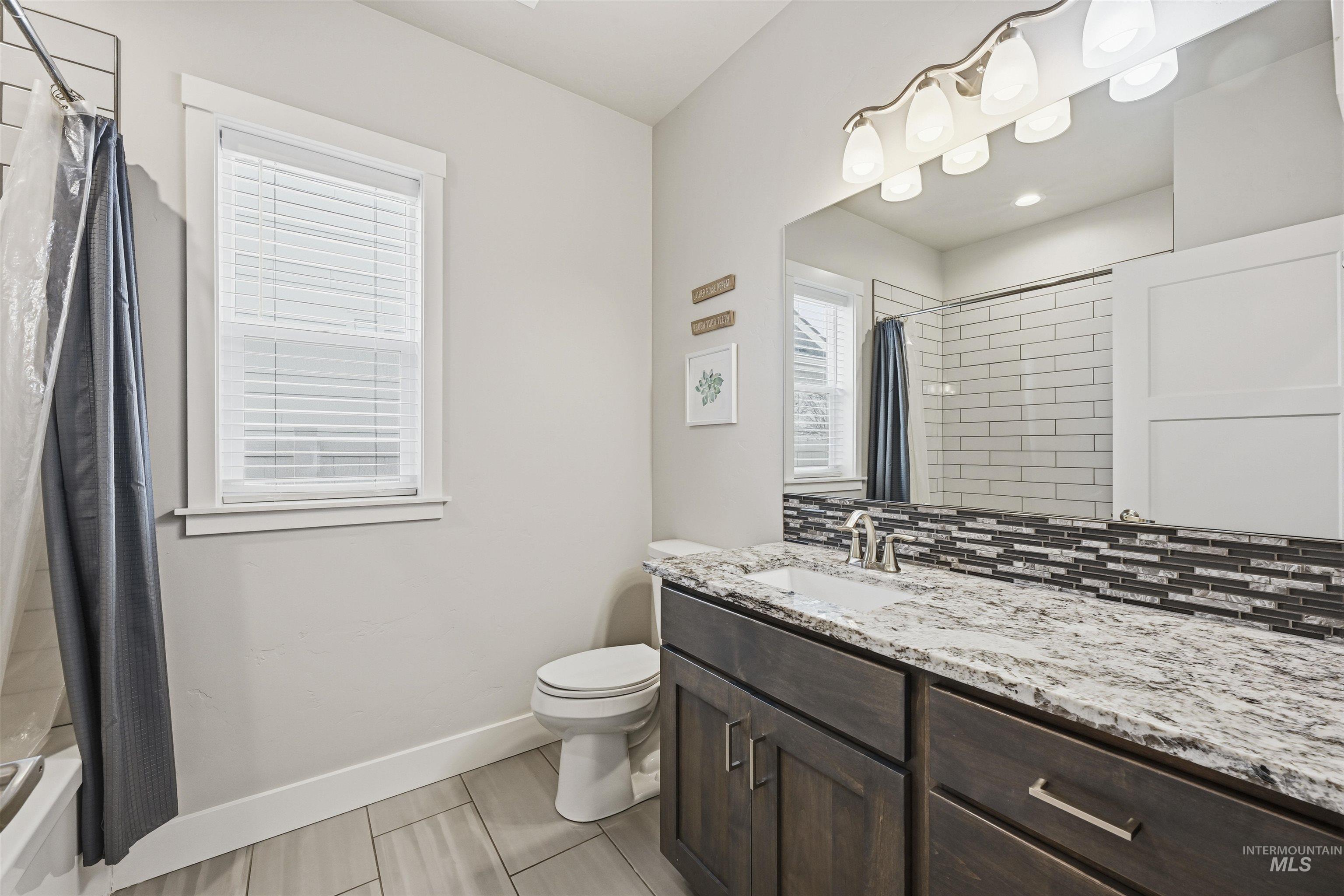 2229 East Grayson Street Meridian, ID 83642 - Photo 30 of 40 Full bath with vanity, shower / bath combination with curtain, and backsplash