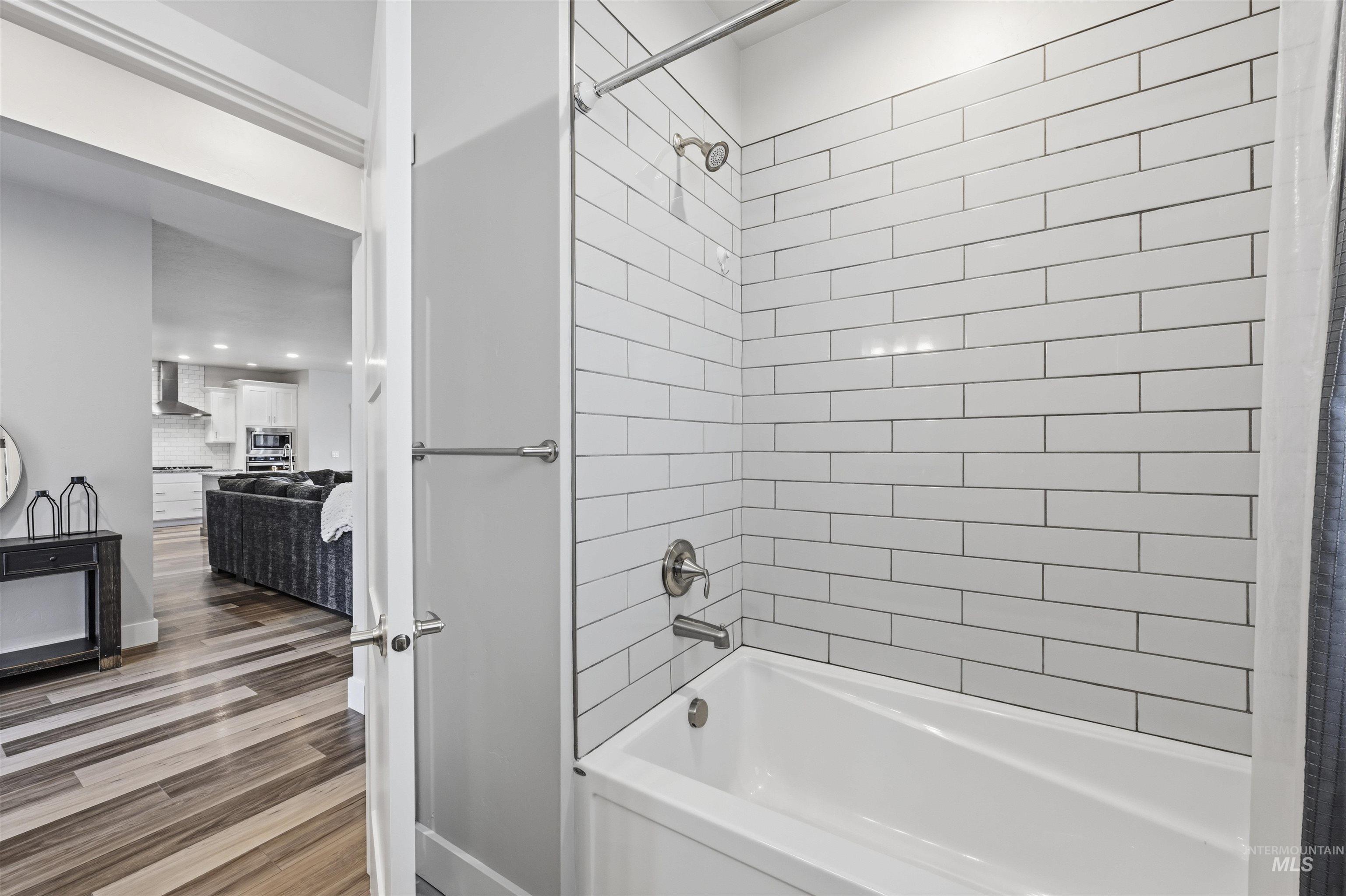 2229 East Grayson Street Meridian, ID 83642 - Photo 31 of 40 Full bathroom featuring washtub / shower combination, dark wood-type flooring, and connected bathroom