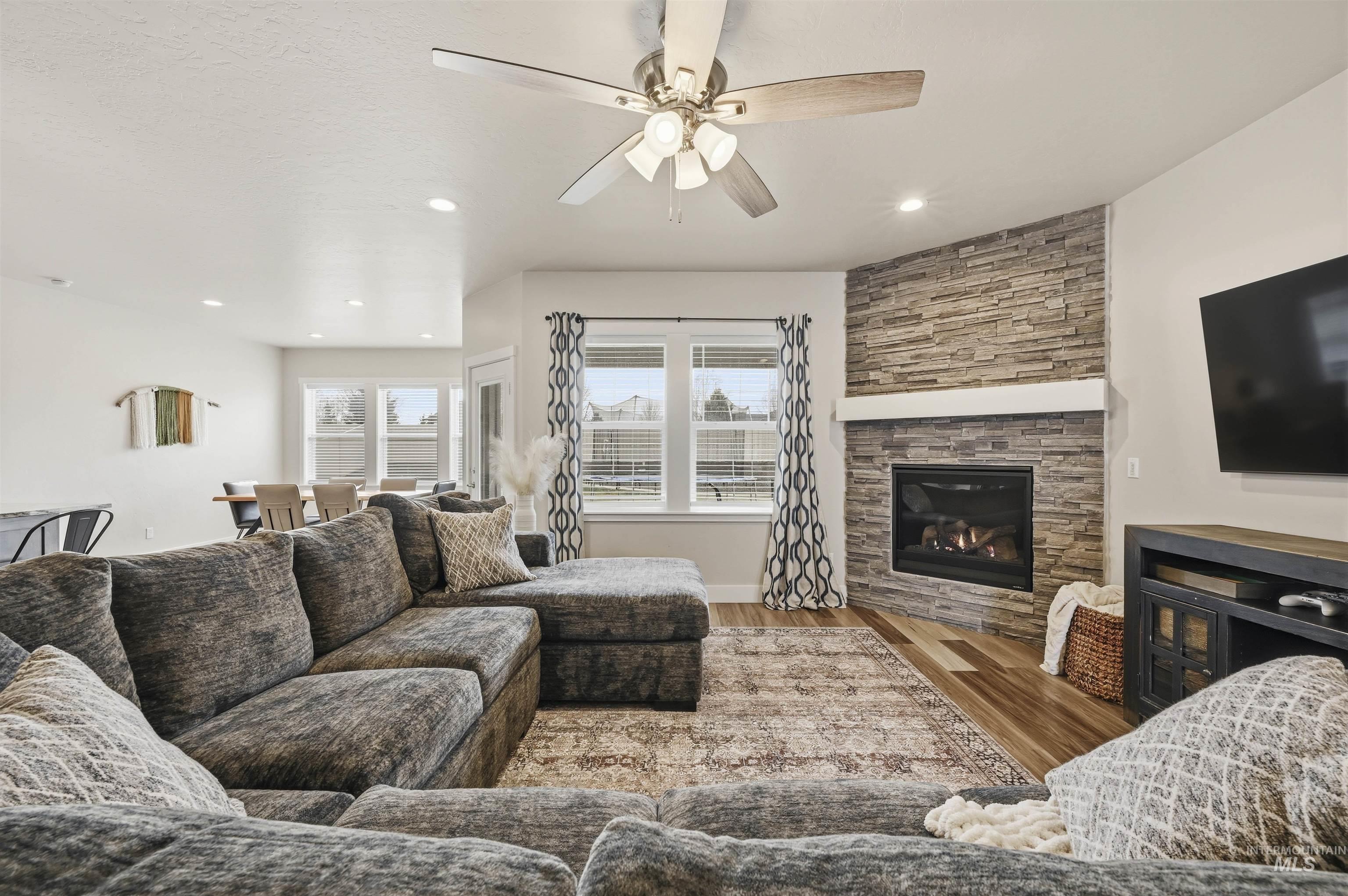 2229 East Grayson Street Meridian, ID 83642 - Photo 5 of 40 Living room with light wood finished floors, ceiling fan, and a fireplace
