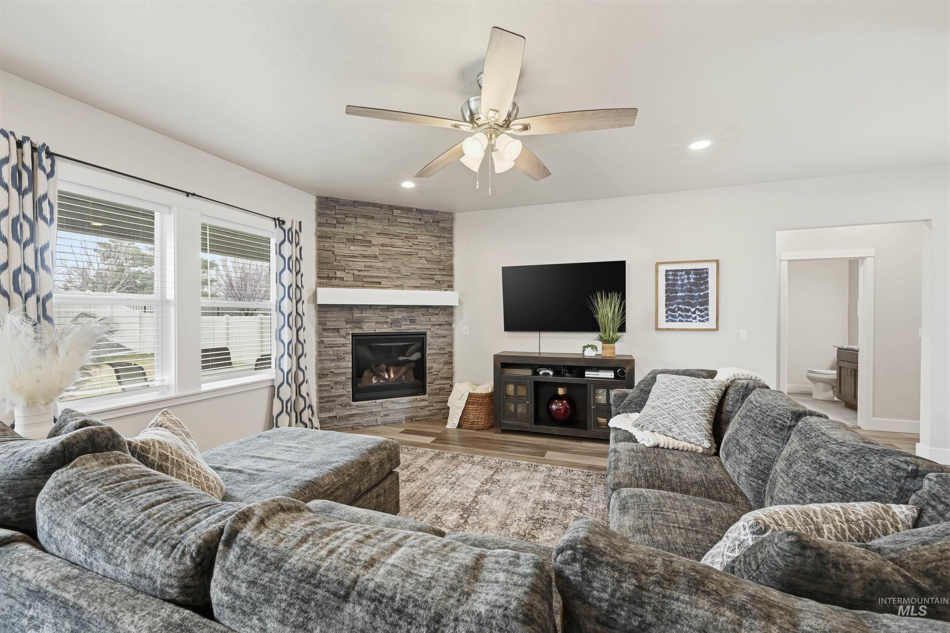 2229 East Grayson Street Meridian, ID 83642 - Photo 6 of 40 Living room featuring a stone fireplace, wood finished floors, ceiling fan, and recessed lighting