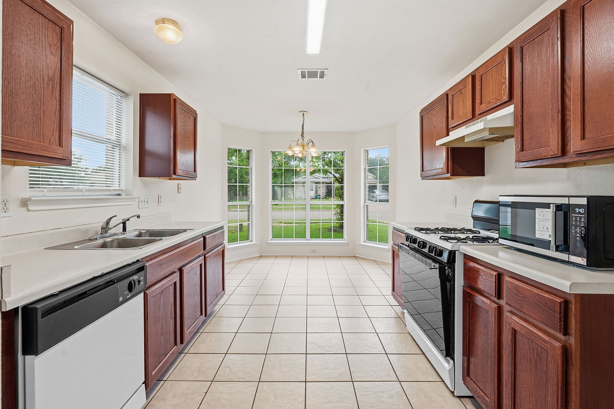 116 Blue Ridge Trail Elgin, TX 78621 - Photo 6 of 28 a kitchen with stainless steel appliances granite countertop a stove sink and cabinets